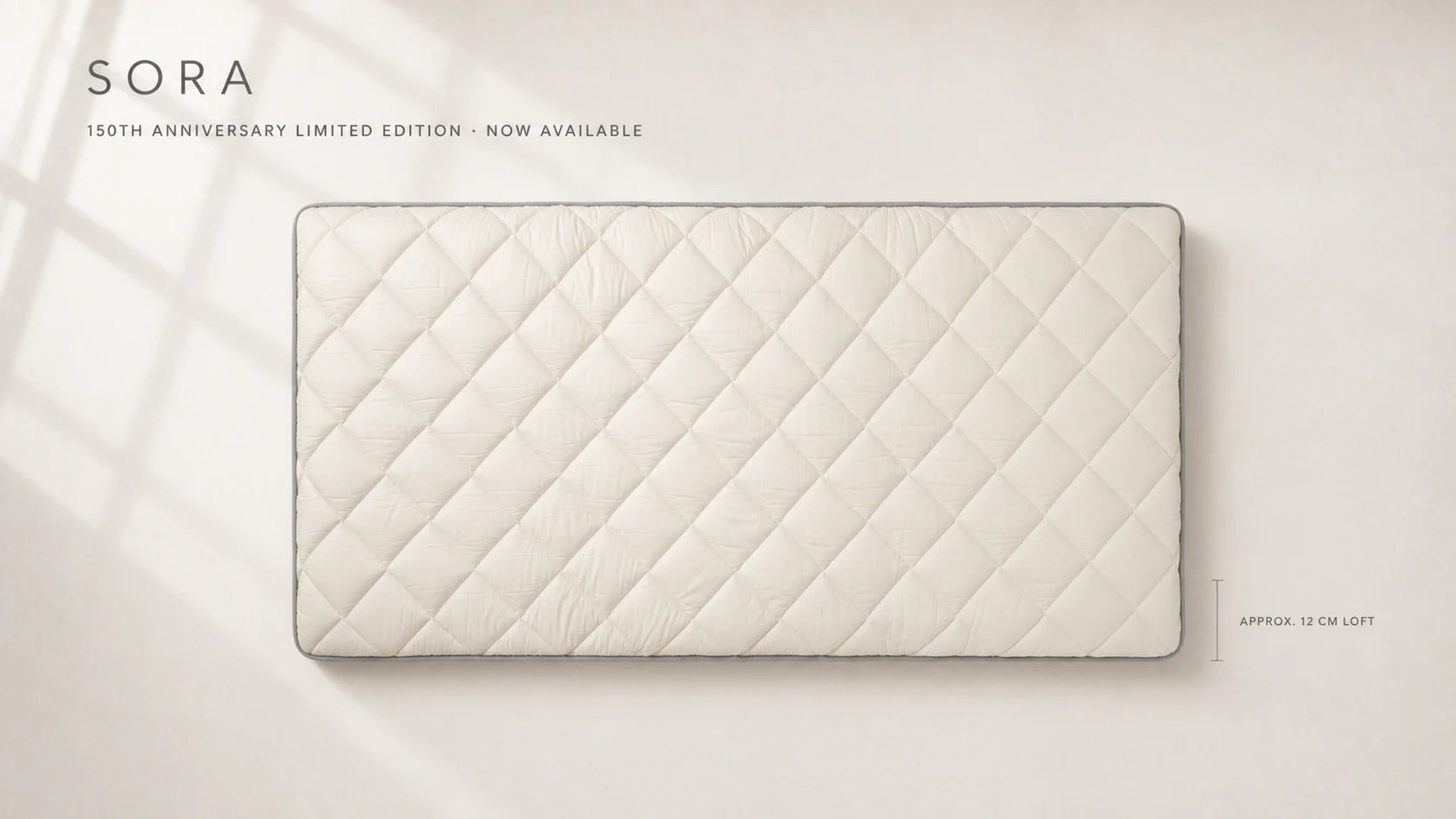 SORA 150th Anniversary Limited Edition laid flat, showing the ivory quilted surface, gray piping, and generous approx. 12 cm loft