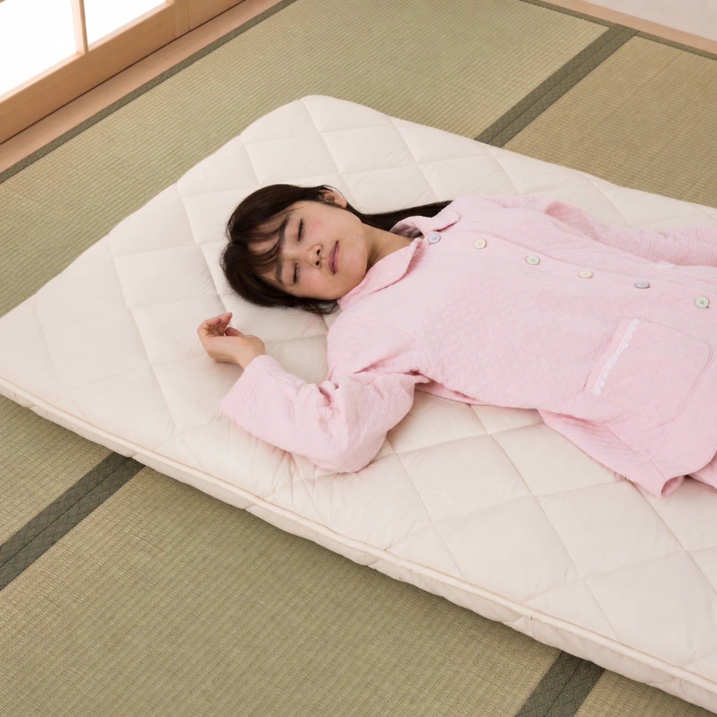 SORA Japanese shikibuton on natural tatami with a sleeper resting