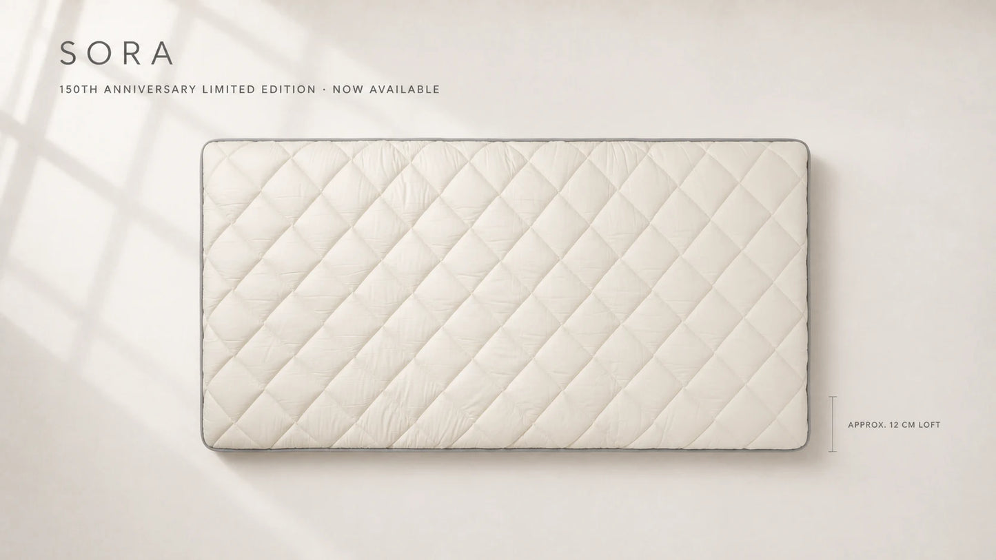 SORA 150th Anniversary Limited Edition laid flat, showing the ivory quilted surface, gray piping, and generous approx. 12 cm loft